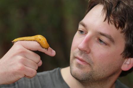 Nathan Bailey holding a yellow caterpillar on his finger